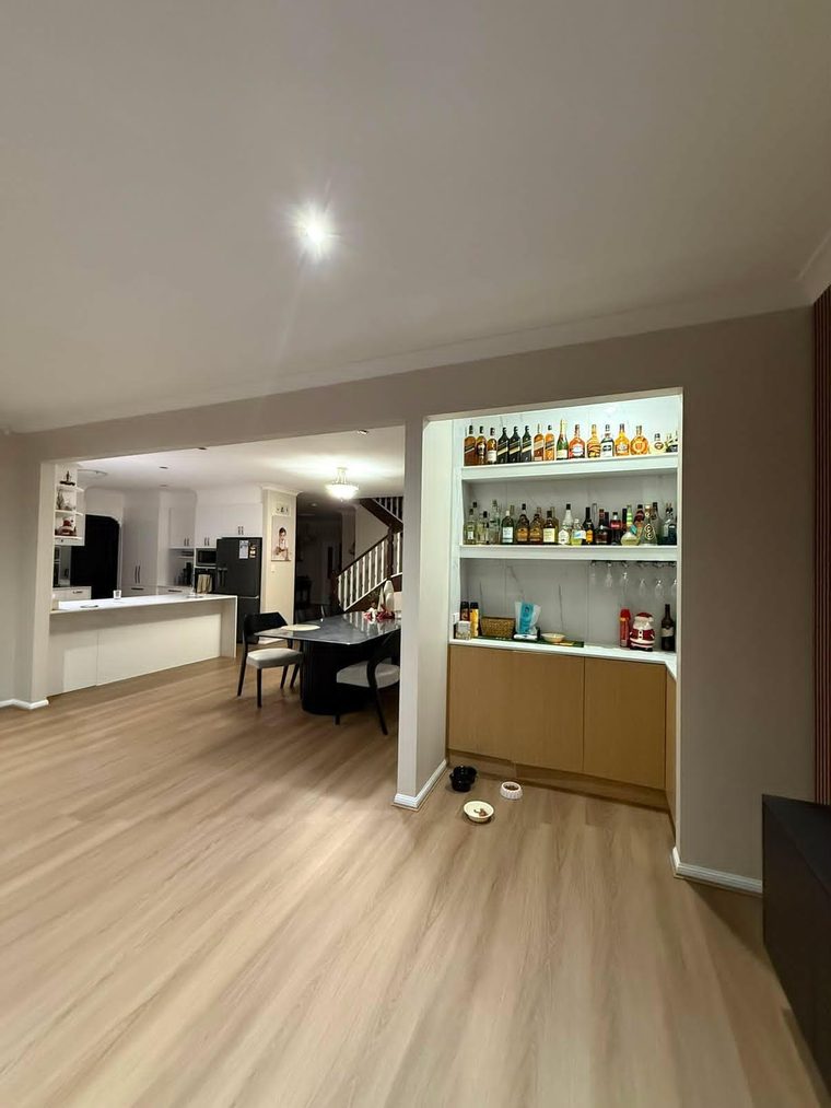 Same level after alterations, opened into one space with new flooring and a built-in bar