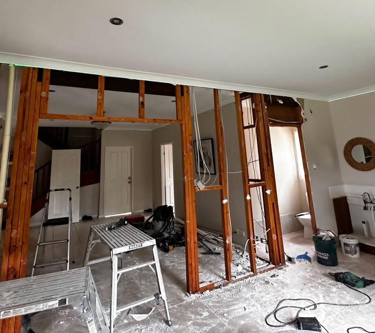 Living area stripped back to the timber frame while a load-bearing wall is removed