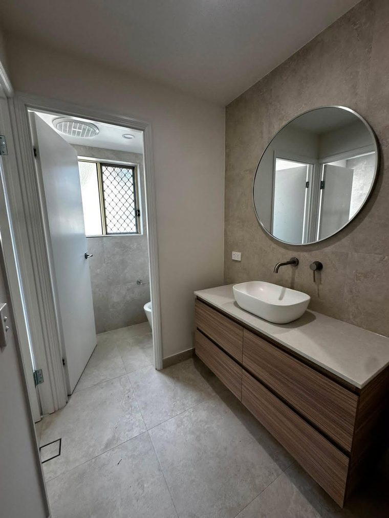 Timber vanity with a stone top, vessel basin and matte black tapware